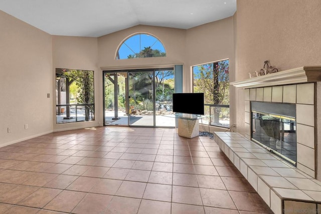 unfurnished living room featuring light tile patterned floors, lofted ceiling, and a tile fireplace