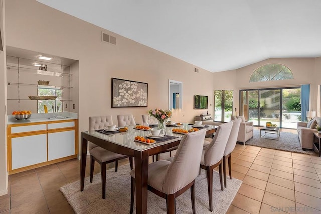 dining area with light tile patterned floors and lofted ceiling