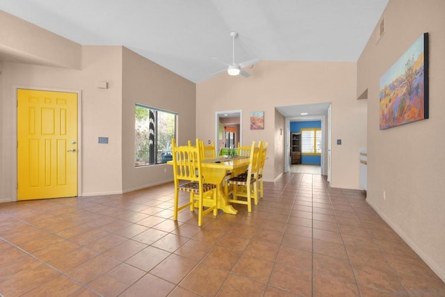 dining area featuring ceiling fan, light tile patterned floors, and high vaulted ceiling