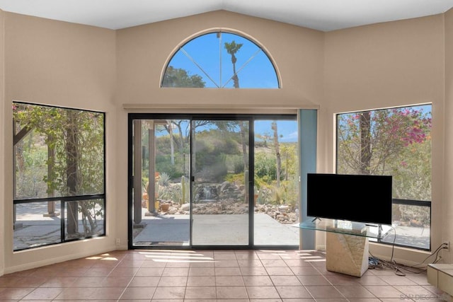 interior space featuring a high ceiling, plenty of natural light, and tile patterned flooring