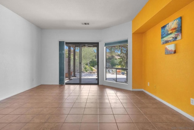 tiled empty room featuring a wealth of natural light