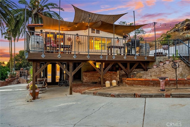 back house at dusk featuring a deck