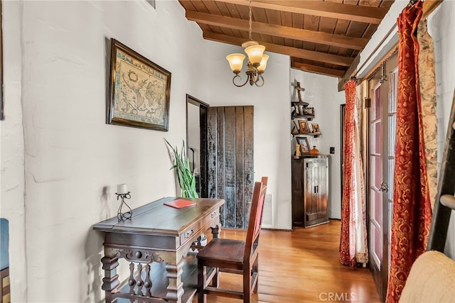 dining space featuring lofted ceiling with beams, wood ceiling, an inviting chandelier, and hardwood / wood-style flooring