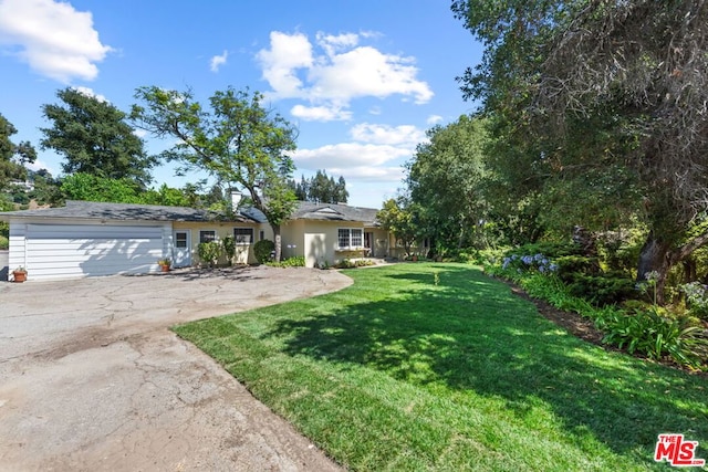 view of front of property featuring a garage and a front lawn