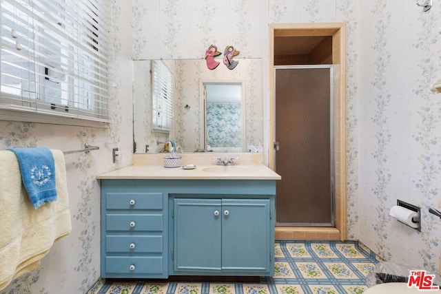 bathroom with a shower with door and vanity