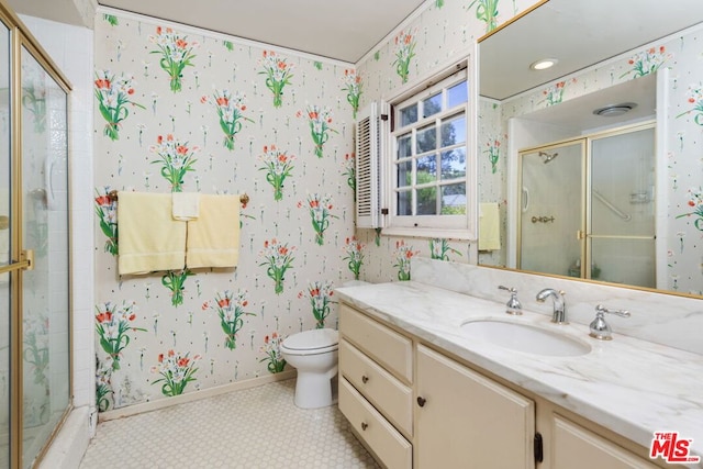 bathroom featuring tile patterned flooring, vanity, toilet, and a shower with shower door