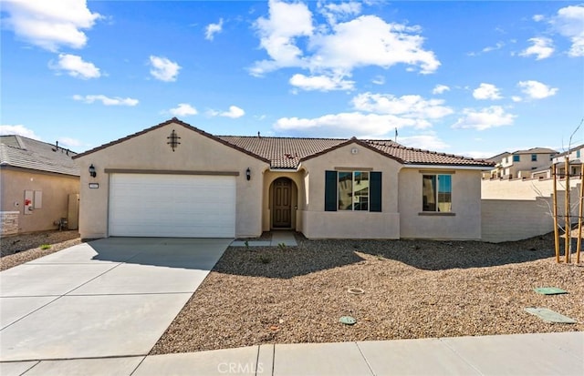 mediterranean / spanish home featuring driveway, a tiled roof, an attached garage, fence, and stucco siding