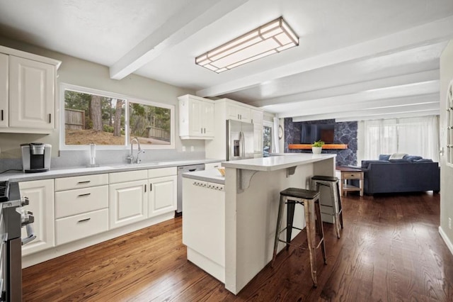 kitchen featuring a kitchen island, beam ceiling, sink, white cabinetry, and stainless steel appliances