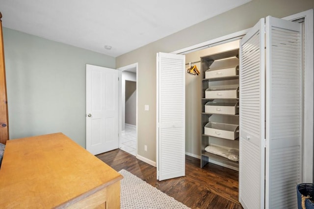 interior space with dark wood-type flooring and a closet