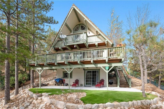 back of house featuring a lawn and a patio