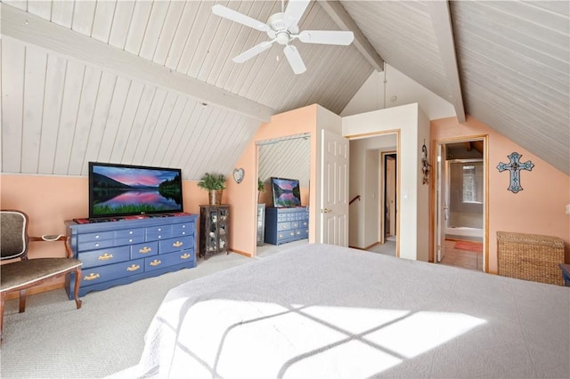 bedroom featuring light carpet, lofted ceiling with beams, ensuite bathroom, and ceiling fan