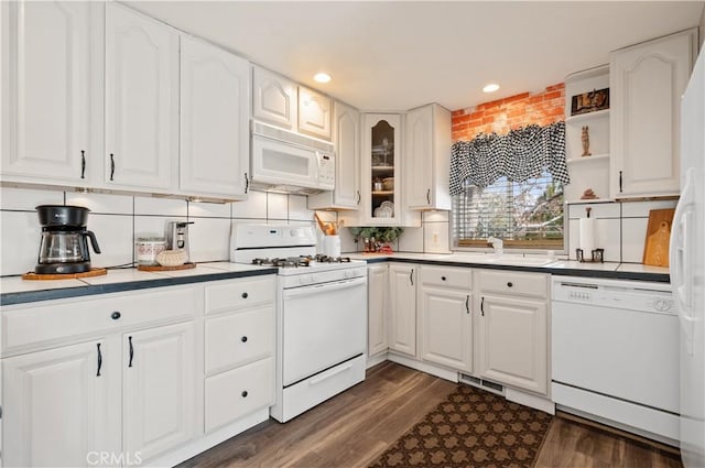 kitchen featuring white appliances, white cabinets, sink, dark hardwood / wood-style floors, and tasteful backsplash