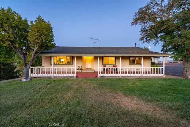 ranch-style home with a porch, stucco siding, and a front lawn
