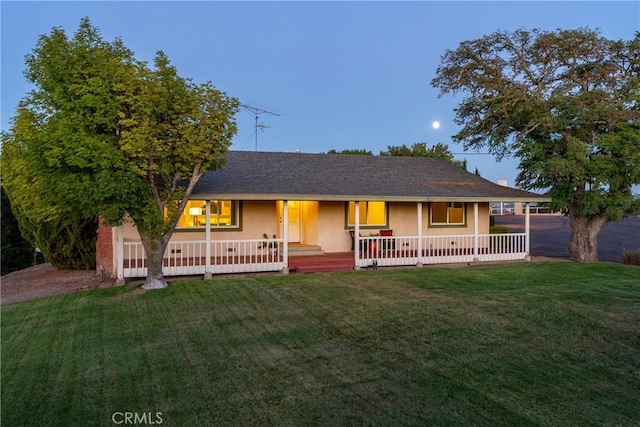 single story home featuring covered porch, a front yard, and stucco siding