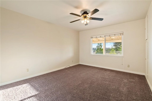 carpeted empty room featuring baseboards and ceiling fan