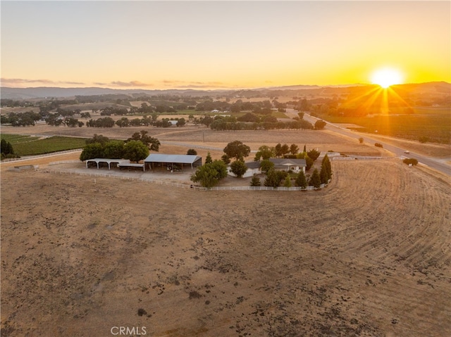 aerial view at dusk with a mountain view and a rural view