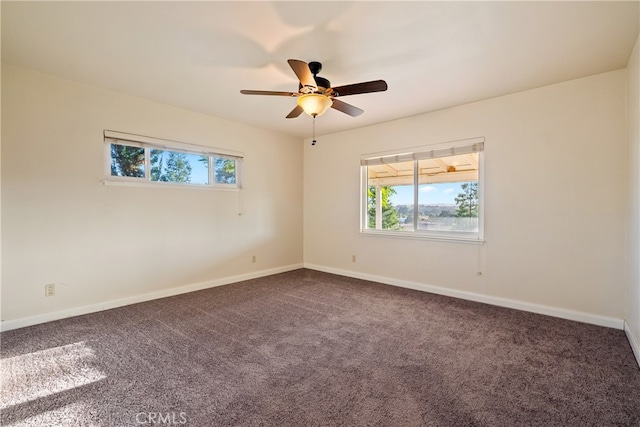 carpeted empty room with ceiling fan and a wealth of natural light