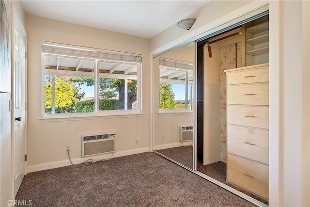 unfurnished bedroom with a closet, dark colored carpet, and an AC wall unit