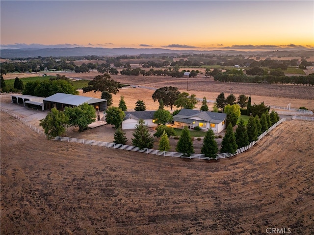 aerial view at dusk with a mountain view and a rural view