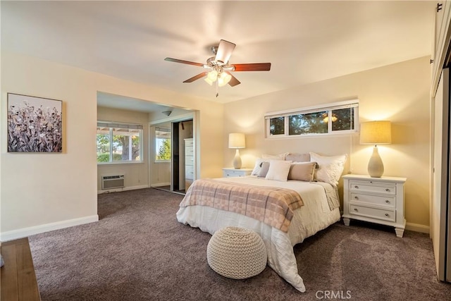 bedroom featuring a wall mounted AC, ceiling fan, dark colored carpet, and baseboards