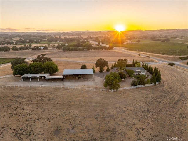 aerial view at dusk with a mountain view and a rural view