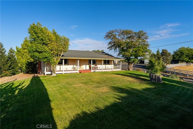 back of house featuring a yard and fence