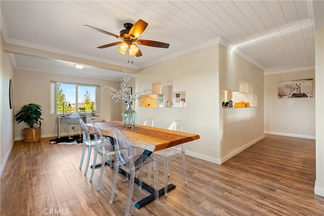 dining area featuring ceiling fan, hardwood / wood-style flooring, crown molding, and wooden ceiling