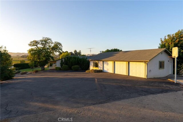 view of front of property with a detached garage, a chimney, and stucco siding