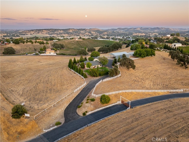 aerial view at dusk featuring a rural view