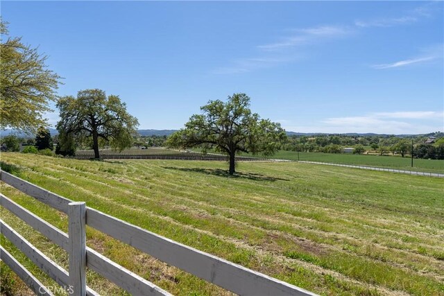 view of yard featuring a rural view and fence