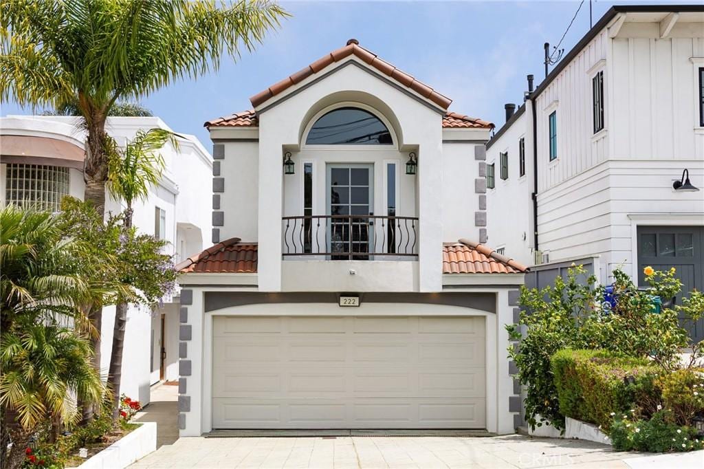 mediterranean / spanish-style home featuring a garage and a balcony