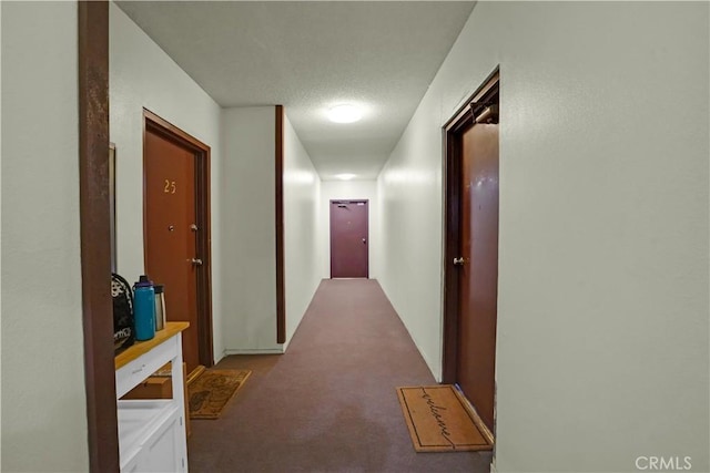 corridor with a textured ceiling and carpet floors