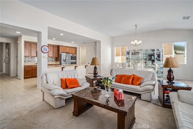 carpeted living room featuring a chandelier and vaulted ceiling