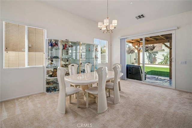 carpeted dining space featuring an inviting chandelier