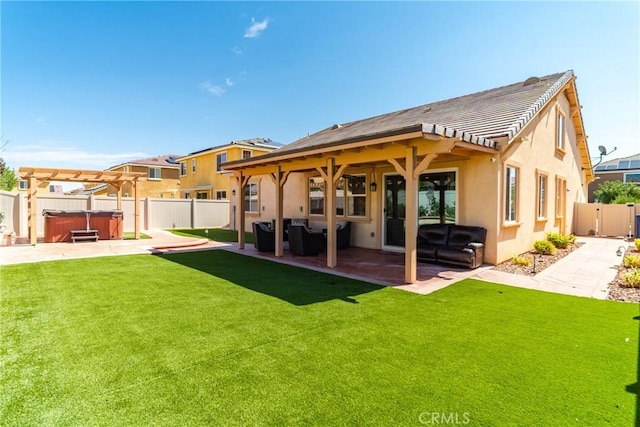 back of property with a lawn, a patio area, a pergola, and a hot tub