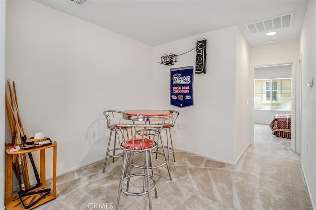 dining area featuring light carpet