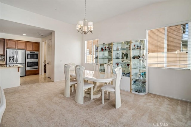 dining room with light colored carpet and a chandelier