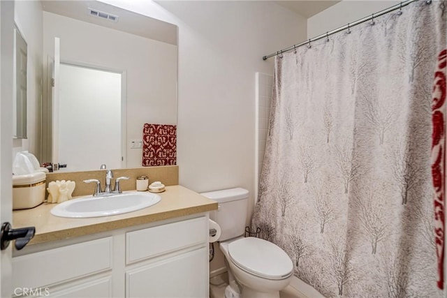 bathroom with vanity, toilet, and walk in shower