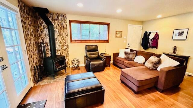 living room with light wood-type flooring and a wood stove