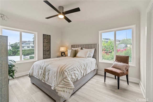 bedroom featuring multiple windows, ceiling fan, and light hardwood / wood-style floors