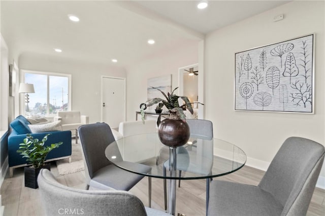 dining area with light wood-type flooring and ceiling fan