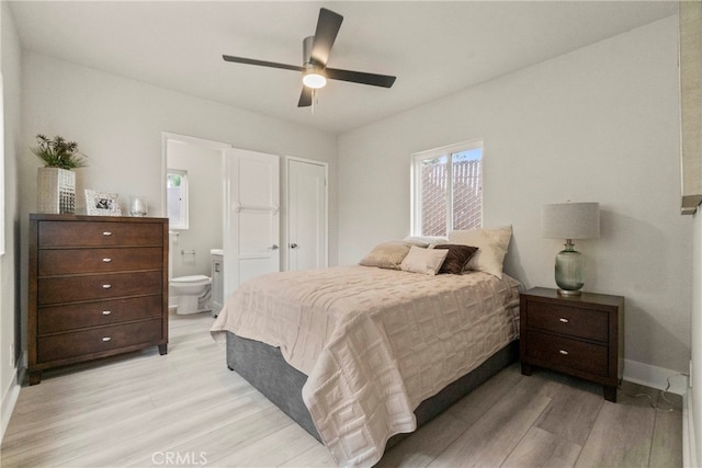 bedroom featuring ceiling fan, light wood-type flooring, and connected bathroom