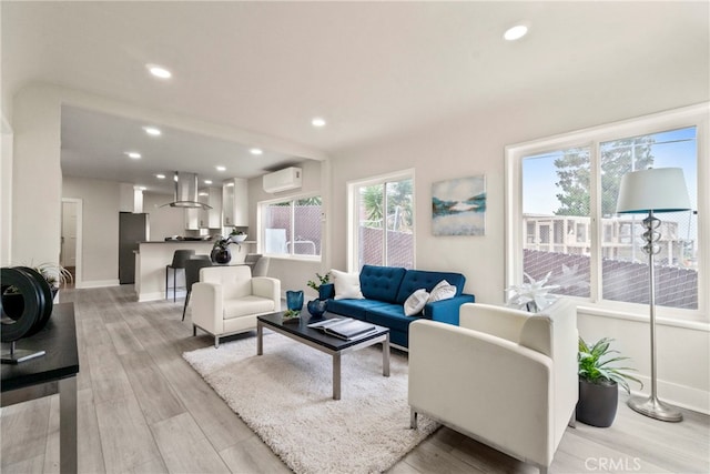 living room featuring a wall unit AC and light hardwood / wood-style flooring