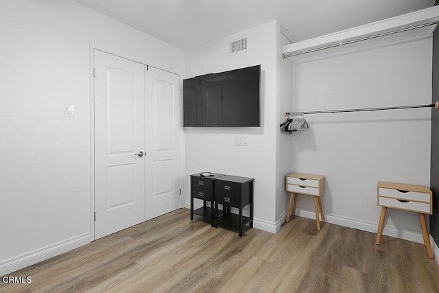 bedroom featuring wood-type flooring and a closet