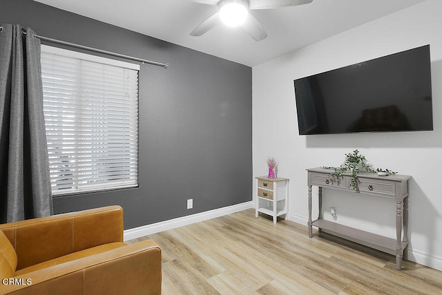 living area featuring light wood-type flooring and ceiling fan