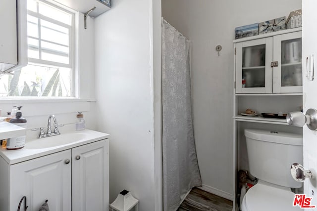 bathroom featuring a shower with curtain, vanity, hardwood / wood-style floors, and toilet