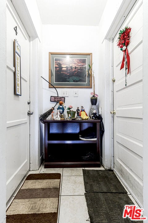 doorway to outside with light tile patterned floors