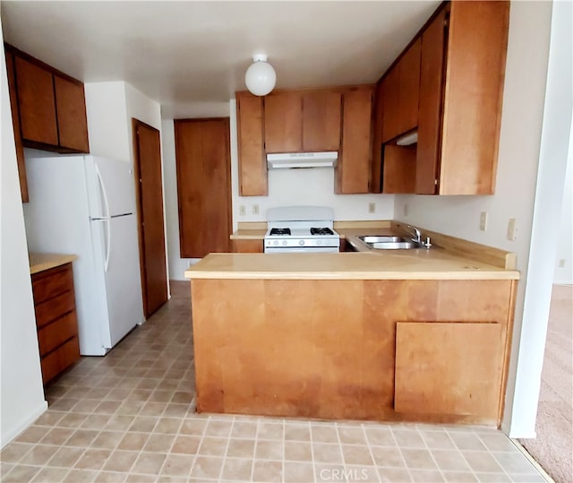 kitchen with sink, kitchen peninsula, and white appliances