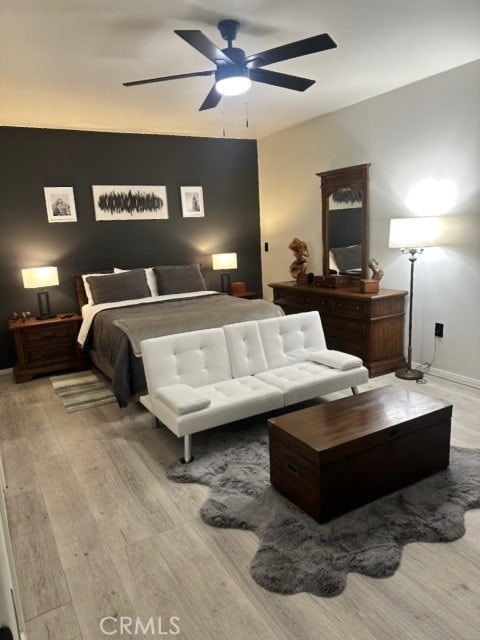 bedroom with light hardwood / wood-style floors and ceiling fan