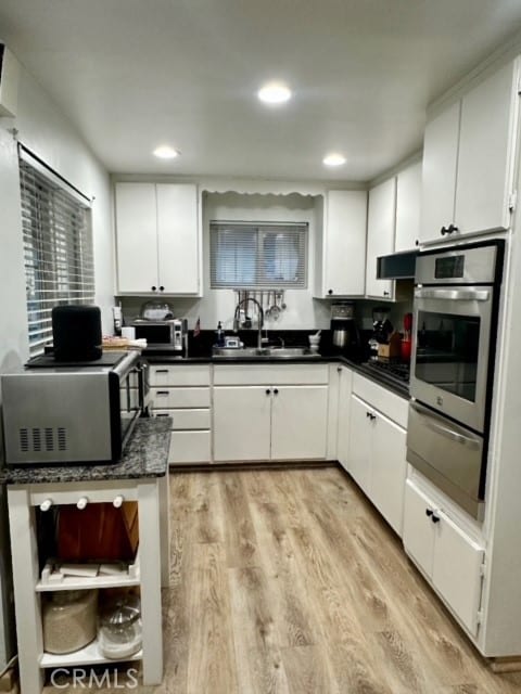 kitchen featuring light hardwood / wood-style flooring, stainless steel appliances, and white cabinetry